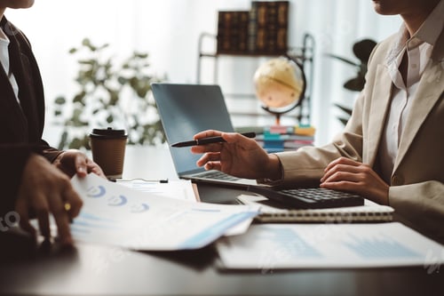 Preview: Business partners analyzing financial data and discussing company performance during an office meeti