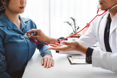 Preview: Doctor examining female patient's heart with a stethoscope during a medical consultation at a clinic