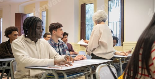 Preview: Teacher distributing papers to diverse students in classroom