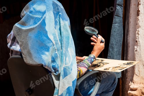 Preview: A person using a magnifying glass to burn wood (pyrography)