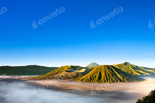 Preview: Sunrise over Mount Bromo reveals majestic volcanic ridges bathed in golden light, surrounded by mist