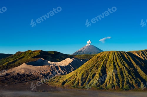 Preview: Sunrise over Mount Bromo reveals majestic volcanic ridges bathed in golden light, surrounded by mist