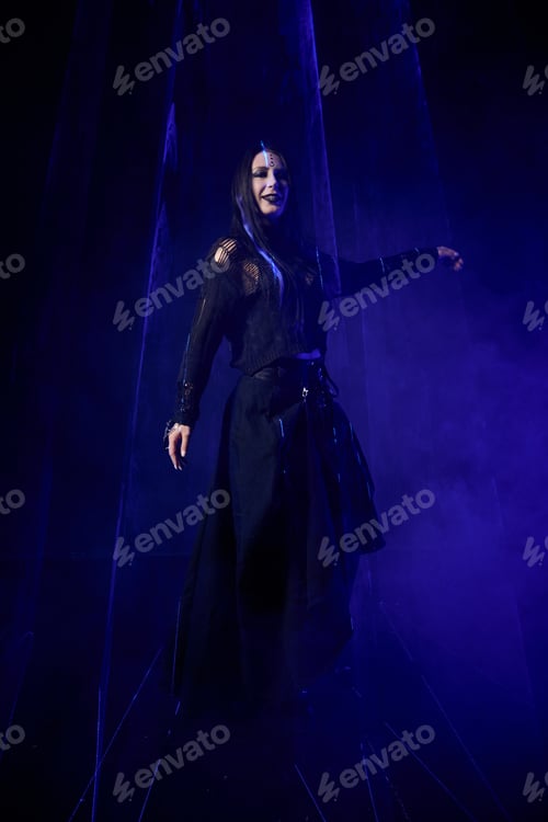 Preview: Gothic young woman with long black hair wearing dark dress in blue foggy light
