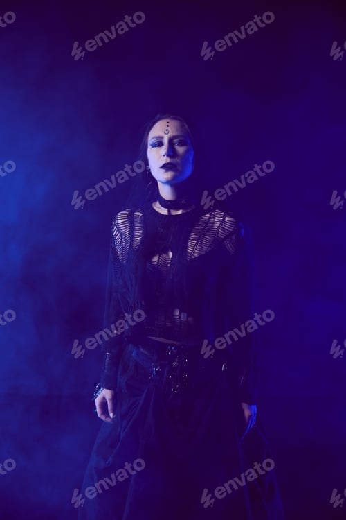 Preview: Young woman with long black hair in gothic black dress under blue mist lighting