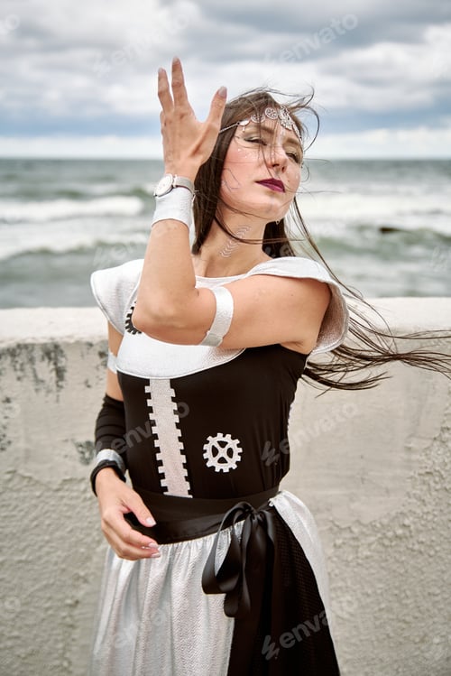 Preview: Young woman cosplay black white steampunk dress wind ocean background confident pose