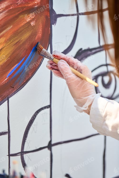 Preview: Artist painting abstract lines and shapes with vibrant warm colors on canvas