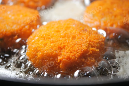 Preview: Golden fritters sizzling in hot oil in a kitchen setting