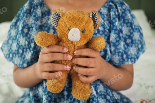 Preview: Holding a cherished teddy bear, a moment of childhood joy