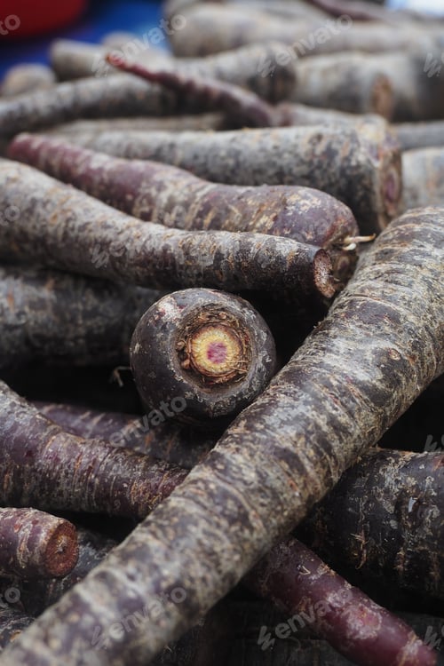 Preview: Purple root vegetables are stacked together in a market