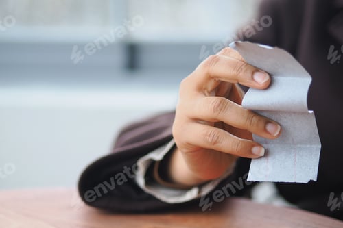 Preview: Hand holding a piece of paper in a casual setting