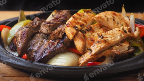 Preview: Delicious grilled meat served with vegetables on a hot plate
