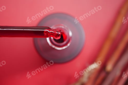 Preview: Red Cosmetic Serum Dropper Over Glass Bottle On Vibrant Red Background, Close-Up Beauty Product