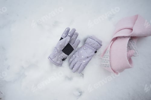 Preview: Gloves and scarf placed on snow in winter