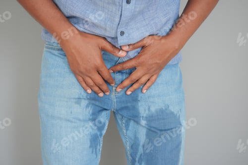 Preview: A Person With a Large, Visible Wet Stain on Their Light Blue Denim Jeans, Centered in the Pelvic Are