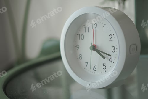 Preview: Clock showing time on a table near a window