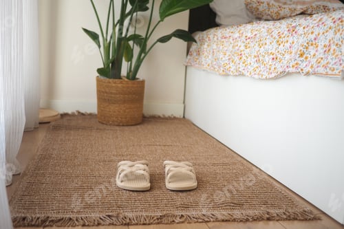Preview: Cozy slippers on a mat near a bed and a plant