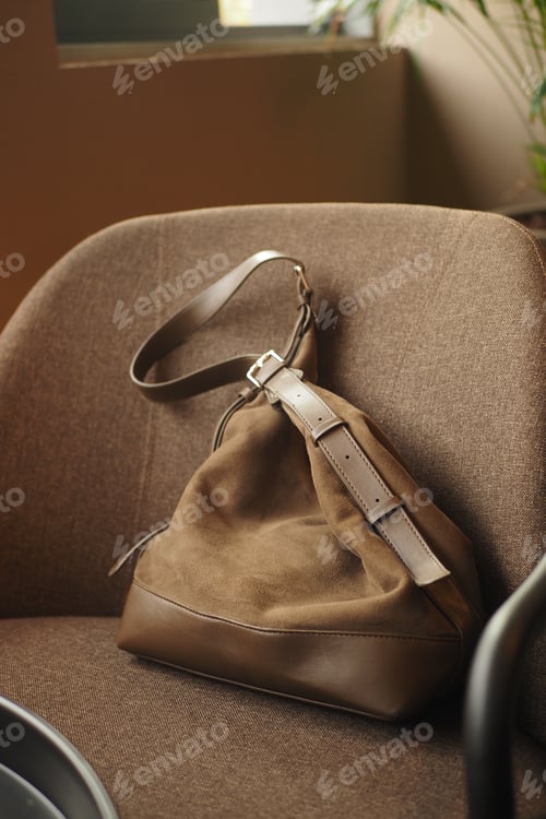 Preview: Brown bag rests quietly on a chair near a window