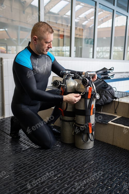 Preview: Close-up of a scuba diver preparing air cylinders at an indoor training pool