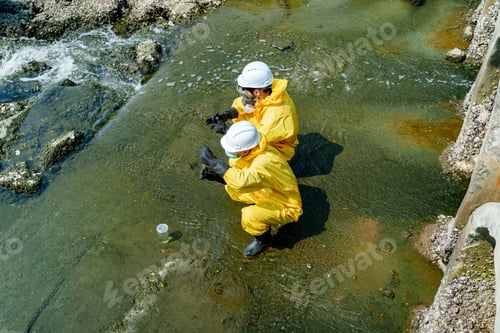Preview: Two workers collect samples near the shore during a research project to test water quality