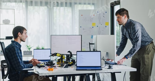 Preview: Team of male developers work code control robotics system and software automation project write prom