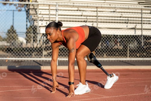 Preview: Paralympic athlete with prosthetic leg waiting to take off on sprint starting blocks