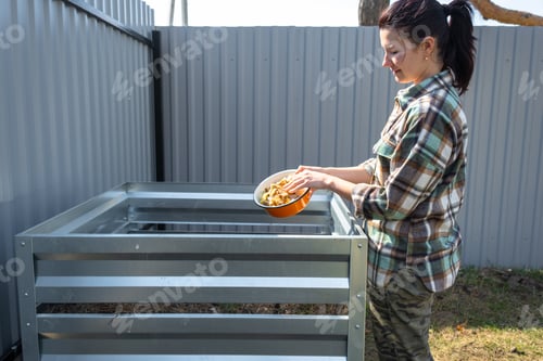 Preview: Adding kitchen food scraps and grass to metal compost bin, home composting process, sustainable orga
