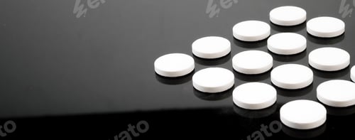Preview: Some white pills aligned isolated on black background, conceptual image
