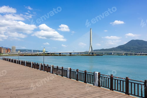 Preview: Wooden seaside walkway overlooking modern Danjiang Bridge in Tamsui Taiwan