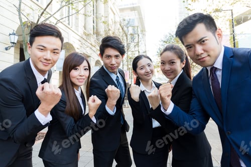 Preview: Group of business people cheerp up with holding arm fist together