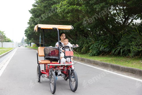 Preview: Mother carrying baby riding bicycle outdoors