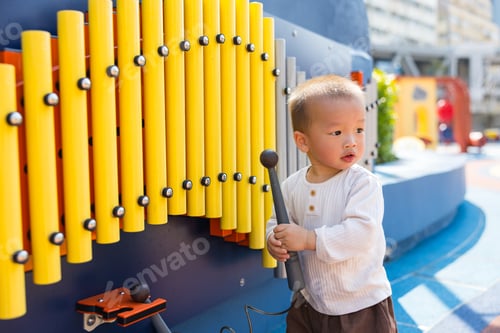Preview: Little boy playing metallophone instrument at outdoor park