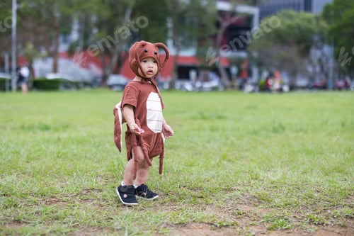 Preview: Toddler wearing cockroach costume enjoying Halloween celebration outdoors