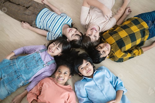 Preview: Top view of multicultural school kids lying on the floor in a circle
