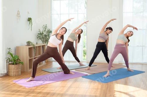 Preview: Women Practicing Reverse Warrior Pose in a Yoga Class in a Bright Room During the Day