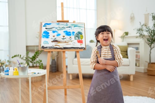 Preview: Child Enjoys Painting in a Bright Indoor Space With Creative Supplies and a Canvas in View