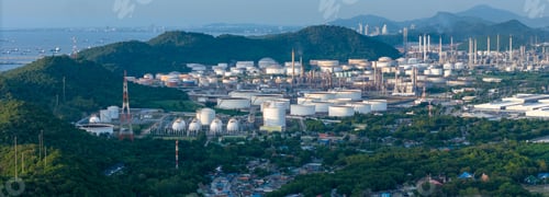 Preview: Large Oil Refinery and Petrochemical Plant With White Storage Tanks and Smokestacks Near the Sea and