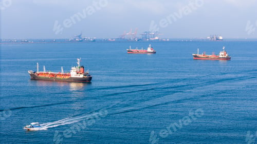 Preview: LPG gas and oil tanker ships anchored in the ocean, with a fast patrol boat in the foreground. Globa