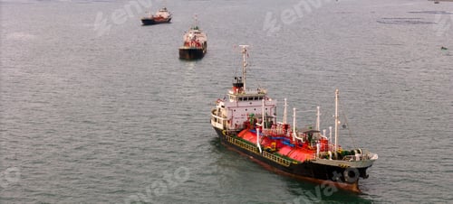 Preview: LPG tanker ship transporting liquefied petroleum gas near an industrial port terminal at twilight. G