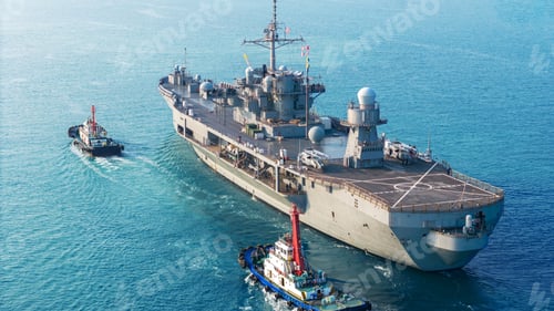 Preview: large naval amphibious assault ship being assisted by tugboats in the strategic Strait of Hormuz. Co