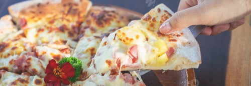 Preview: delicious pizza slice with melted stretching cheese held by a smiling woman. Concept of food sharing