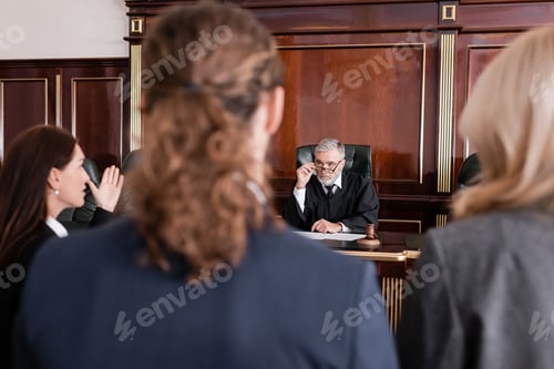 Preview: Prosecutor Pointing With Hand While Talking to Judge Near Blurred Man and Advocate