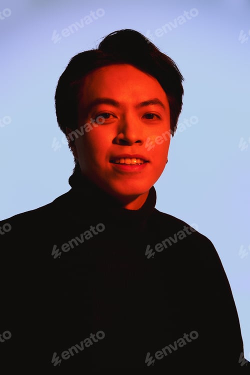 Preview: Trendy young man showcasing individuality with bold fashion in a studio