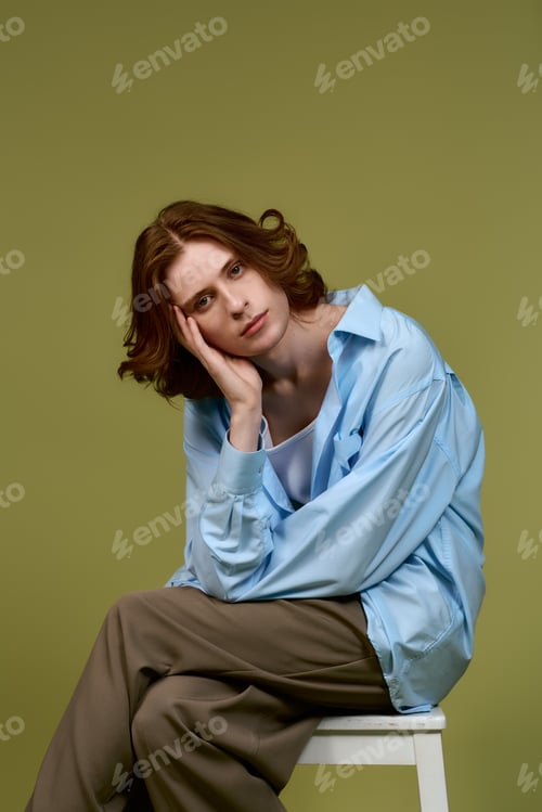 Preview: Stylish young man poses thoughtfully in a modern studio space