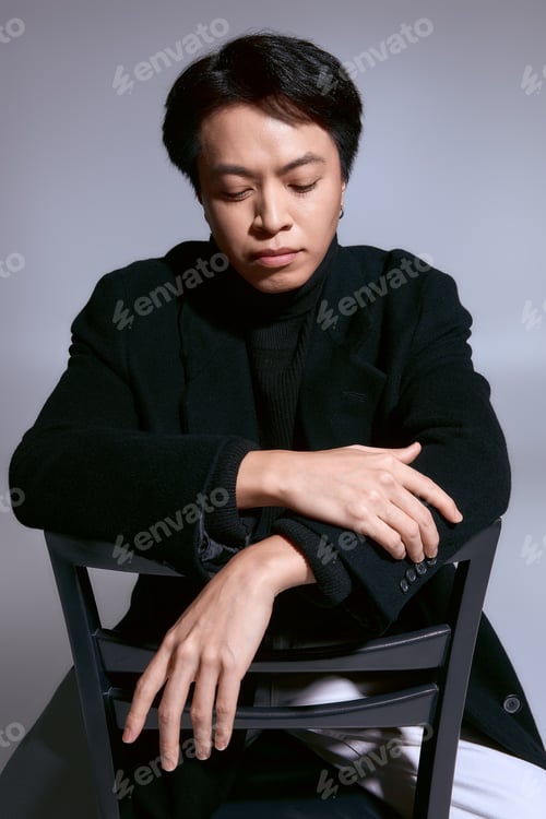 Preview: Stylish Asian young man displays modern fashion sense in studio setting with creativity