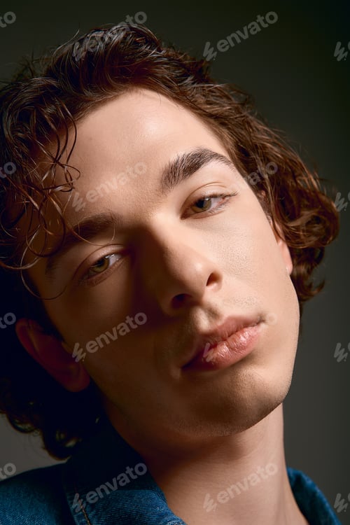 Preview: Emotional young man with curly hair expresses deep thoughts in stylish attire