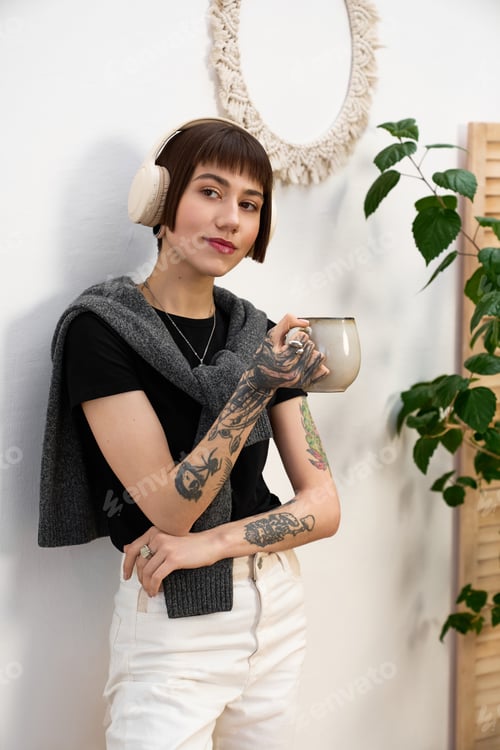 Preview: Young beautiful woman enjoys a quiet moment at home with a warm drink in hand