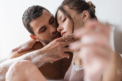 Preview: Bearded man touching pretty girlfriend in bathtub with foam