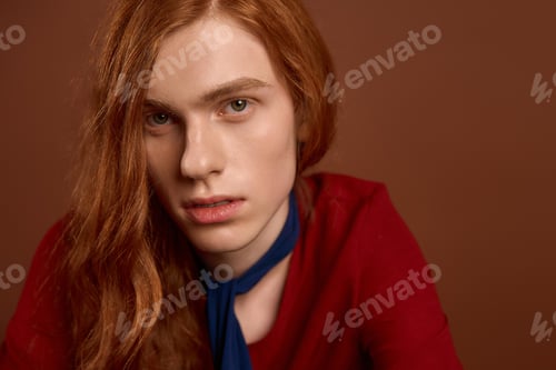 Preview: Handsome young man with long red hair showcases elegant style in a stunning pose