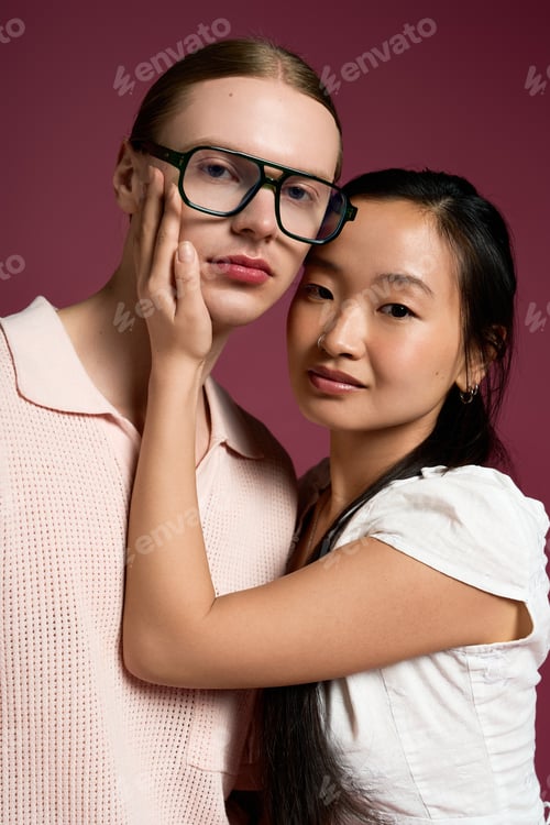 Preview: Young couple sharing a tender moment under soft lighting with a warm backdrop