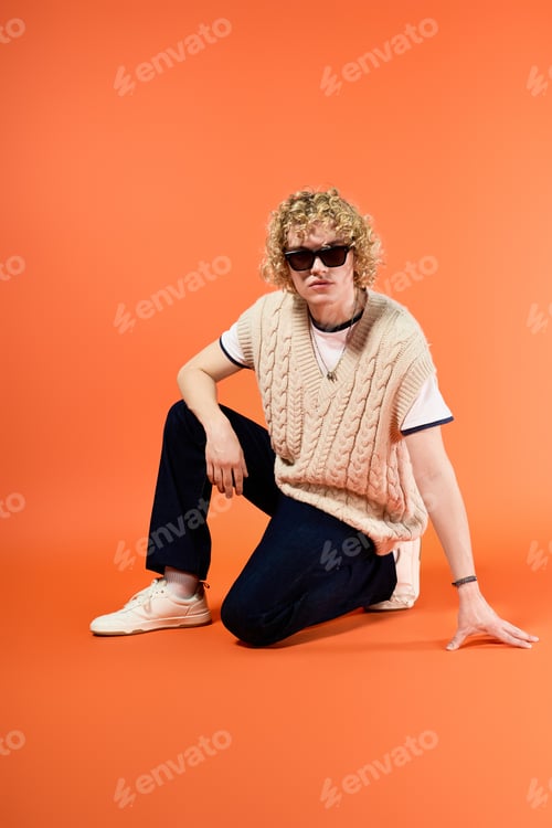 Preview: Curly blonde young man showcasing trendy student fashion in vibrant studio setting